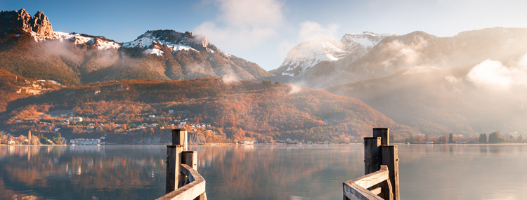 snow topped mountains autumn coloured trees and lake view from wooden outlook